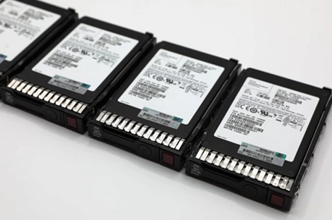 Technician performing RAID hard drive recovery with multiple hard drives and recovery tools.