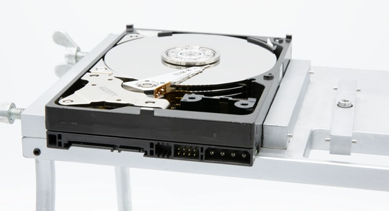 Open hard drive on a mounting platform with exposed platters.